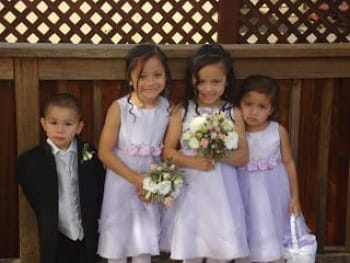 Picture of a little boy in tuxedo & 3 little girls in flower girl dresses