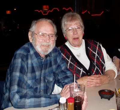 Image of older man & woman (friends) smiling after dinner.