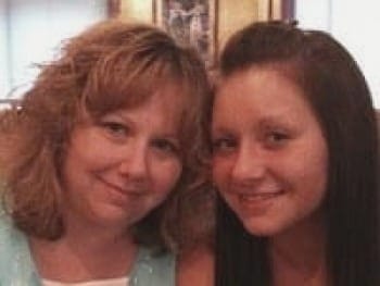 Photo of woman and her teenage daughter, their faces cheek-to-cheek