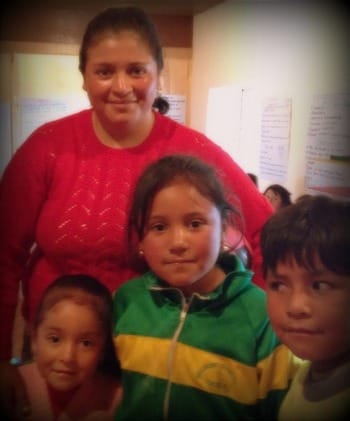 Photo of Ecuadorian mother in red sweater, with her 3 children (2 girls and a boy)