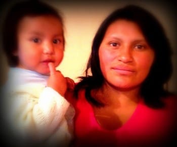 Photo of young Ecuadorian mother with her toddler girl on her hip.