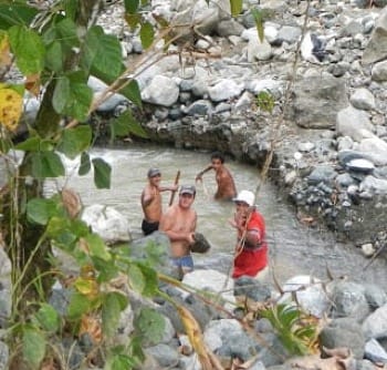 Photo of several men in river, called 'gold seekers.'