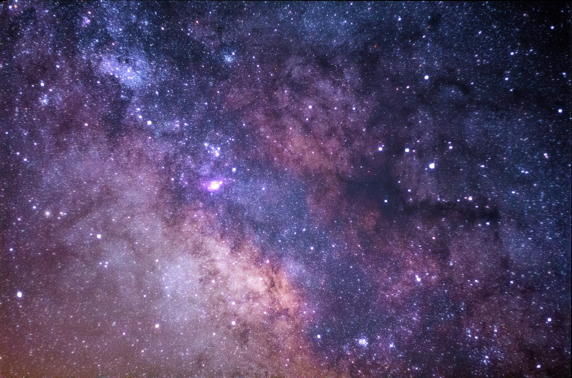 Photo of deep night sky studded with stars on a purple-magenta background