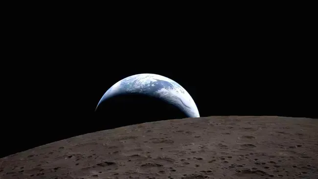 Photo looking over a curve of moon at the earth.