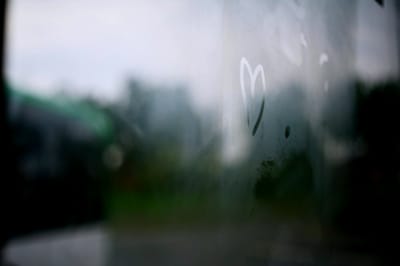 Photo of steamy window with a heart drawn by a fingertip on the glass.